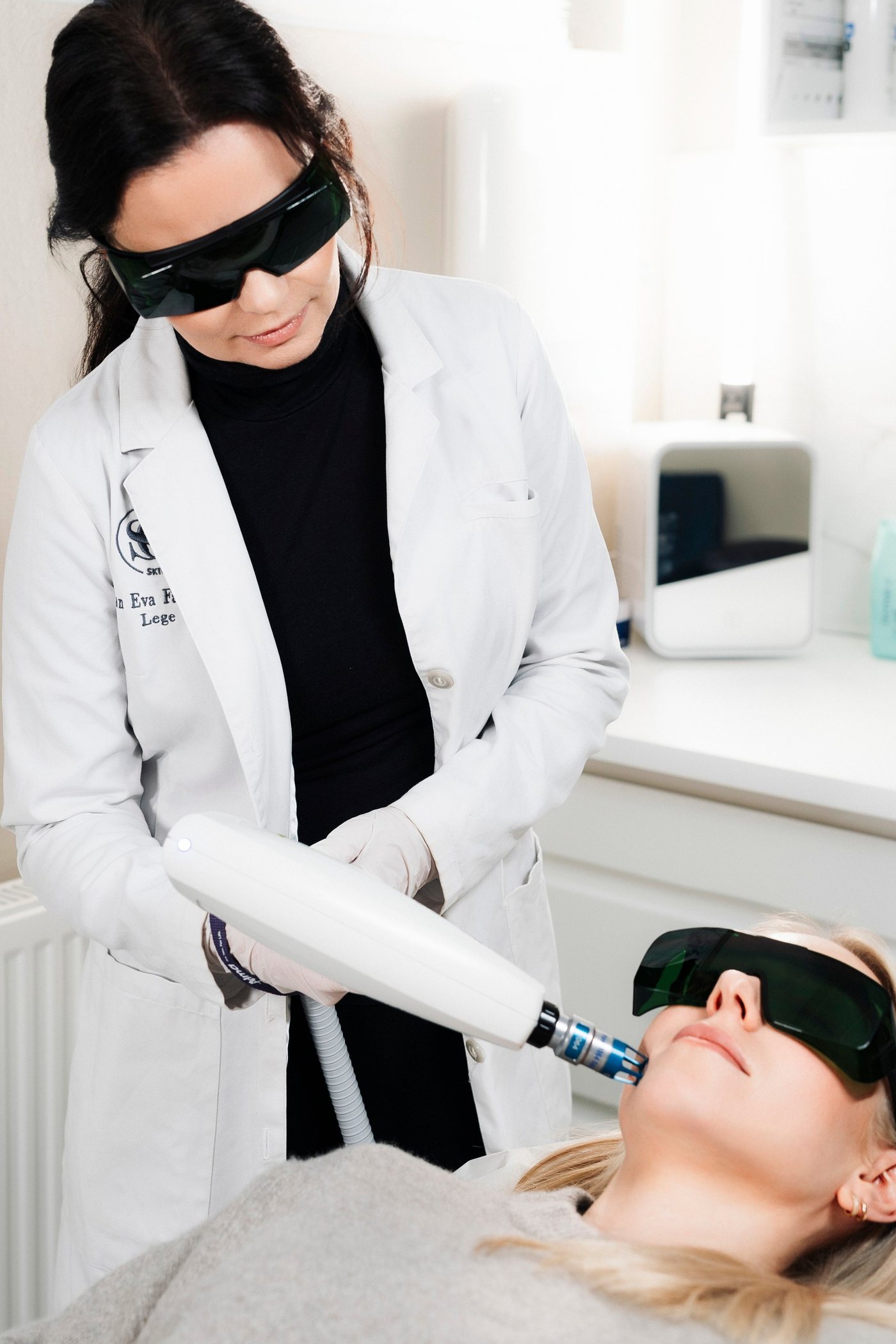 Lege utfører laserbehandling med vernebriller ved Skin Clinic Molde