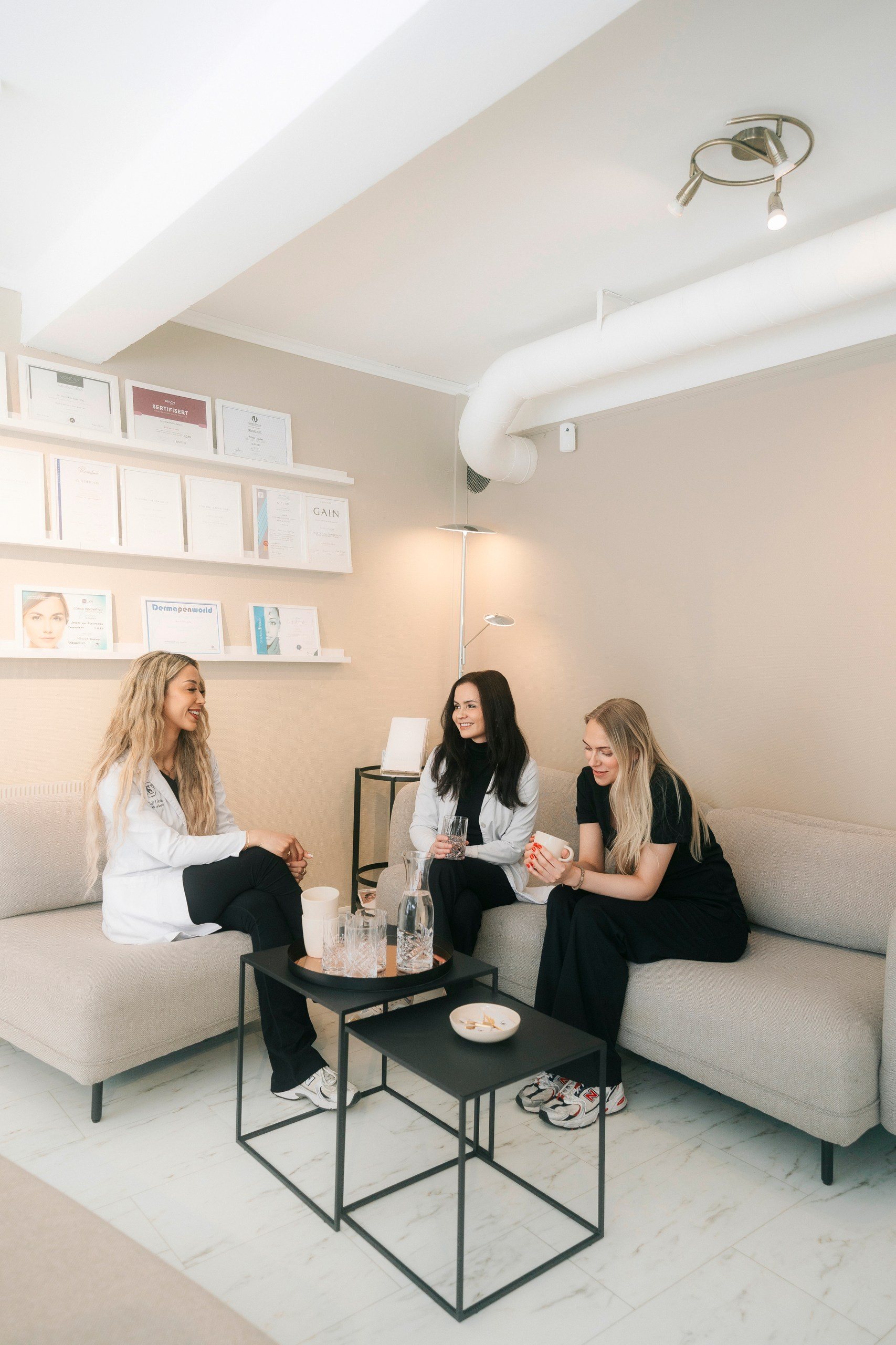 Behandlere i samtale med en kunde i venteområdet hos Skin Clinic Molde